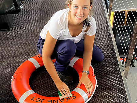 knieende Frau poliert Rettungsring