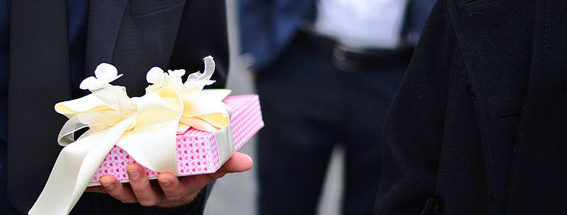 A person, who is holding a gift in his hands.