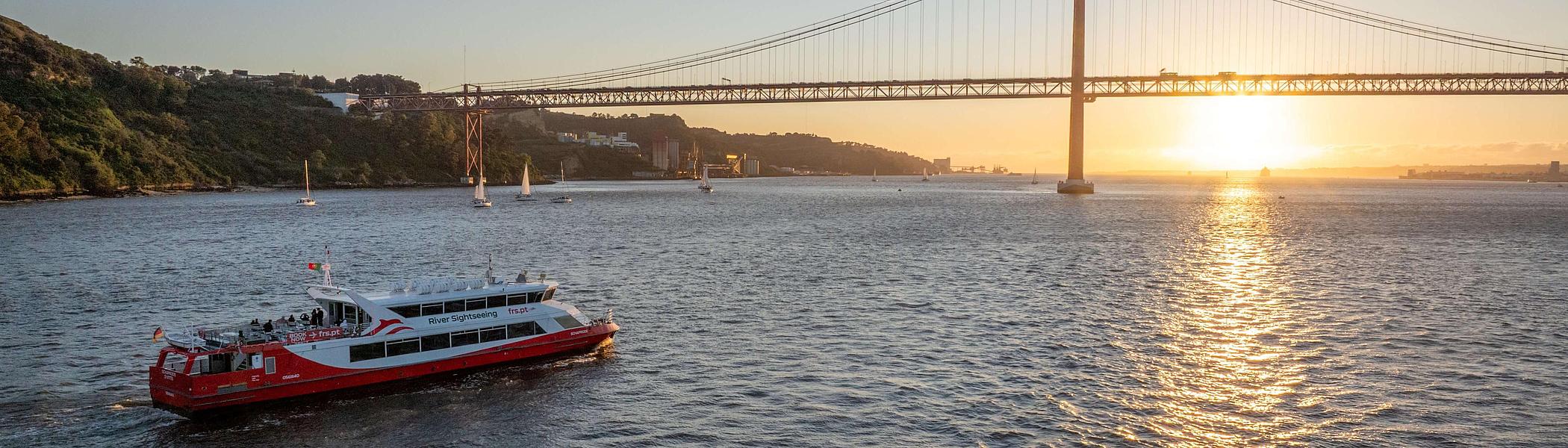 Die Schaprode vor der Brücke des 25. April im Sonnenuntergang